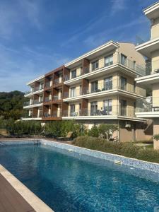 a building with a swimming pool in front of a building at Vivienne Apartment in Kavač