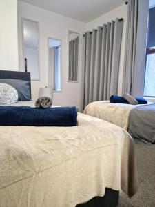 ein Schlafzimmer mit zwei Betten und einem Fenster in der Unterkunft Rook View, Modern Coastal Retreat with Free Parking in Buckie