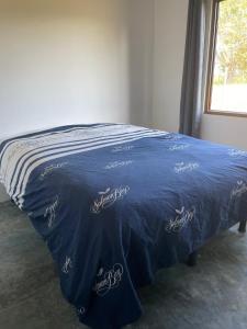 a bed with a blue blanket on top of it at Farmer's house in El Quije