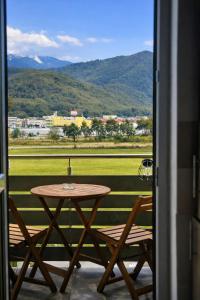 a table and chairs on a balcony with a view at Casa MIO in Braşov