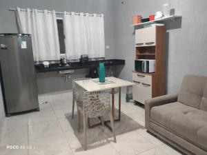 ein Wohnzimmer mit einem Tisch und einem Sofa in der Unterkunft Casa Mineira - Flats novos em Ponta de Mangue - Maragogi in Maragogi