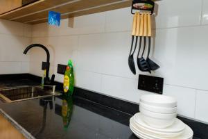 a kitchen with a counter with plates and utensils at Studio Room by Elegushi beach resort in Mama +16 photos