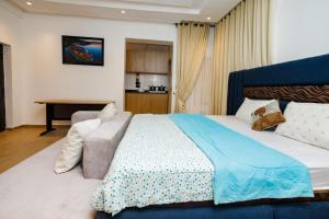 a bedroom with a large bed with a blue blanket at Studio Room by Elegushi beach resort in Mama