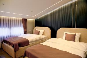 a hotel room with two beds and a window at DejaVu Hotel in Prizren
