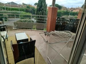 a patio with a table and chairs on a balcony at Bel appartement 3 pièces climatisation in Saint-Alban