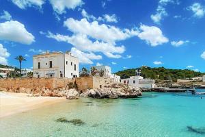 a view of a beach with a building and the water at Palazzo Sisina in Rutigliano