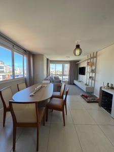 een woonkamer met een tafel, stoelen en een bank bij Apartamento no centro de Torres Rs in Torres