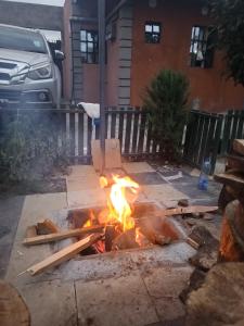 a fire pit in a yard in front of a house at EsMash Homes Air,bnb Lanet Nakuru in Nakuru