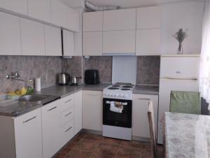 a kitchen with white cabinets and a stove top oven at Jakov's apartment in Bitola