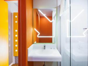 een badkamer met een witte wastafel en een spiegel bij ibis budget Rio de Janeiro Centro in Rio de Janeiro +56 foto's