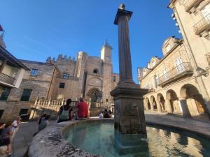 a group of people sitting around a fountain in front of a building at Escola in Ourense