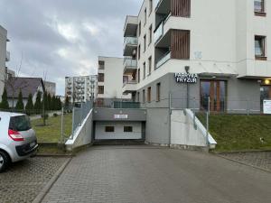 a car parked in a parking lot next to a building at Apartament w Kościerzynie in Kościerzyna