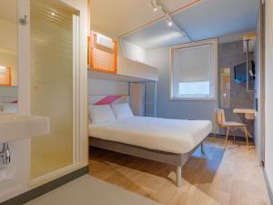 een slaapkamer met een stapelbed en een badkamer bij Ibis Budget Lyon Est Saint Quentin Fallavier in Saint-Quentin-Fallavier