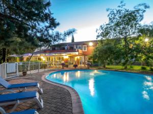 a swimming pool in front of a house at ibis Brignoles Provence Verte in Brignoles