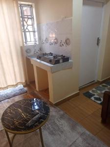 a kitchen with a stove and a table in a room at EsMash Homes Air,bnb Lanet Nakuru in Nakuru