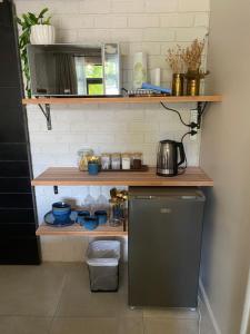 a kitchen with a shelf and a refrigerator at The cozy acre in Potchefstroom
