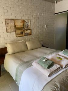 a white bed with towels on top of it at The cozy acre in Potchefstroom