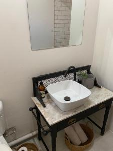 a bathroom with a sink on a table with a mirror at The cozy acre in Potchefstroom +1 photo