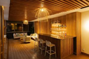 a living room with a bar with chairs and a couch at Résidence LOBOS by Ilios in Dakar