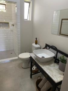 a white bathroom with a sink and a toilet at The cozy acre in Potchefstroom
