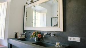 un bagno con un lavandino e un grande specchio di La Escribana a Constantina Altre 39 foto