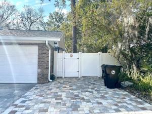 een oprit met een wit hek en een garage bij My Dream Space in Orange Park