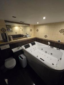 een badkamer met een groot bad en een toilet bij Old Wine House in Klaipėda