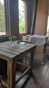 een houten tafel met een bed in een kamer met een raam bij Raices del Mar in La Pedrera