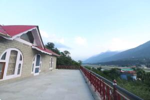een gebouw op een brug met bergen op de achtergrond bij Malti Guest House in Kullu Manali