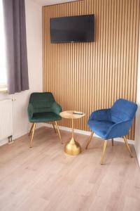 twee stoelen en een tafel in een kamer bij Hotel & Restaurant Hasa in Gernrode - Harz