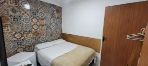 a small room with a bed and a wall at Pousada Primeiro Sol in João Pessoa