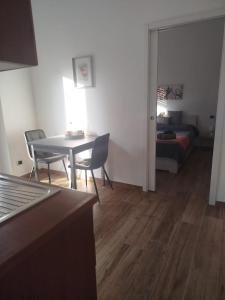 een woonkamer met een tafel, stoelen en een bank bij Bilocale Home Project 2 in Novara