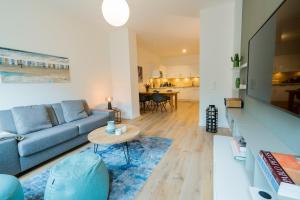 a living room with a blue couch and a table at Wave1 in Norderney