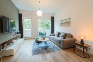 a living room with a couch and a tv at Wave1 in Norderney