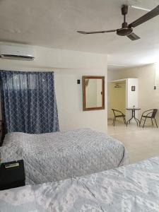 een slaapkamer met twee bedden en een plafondventilator bij Casa Polito in Izamal +25 foto's