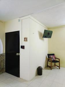 een kamer met een zwarte deur en een stoel bij Casa Polito in Izamal