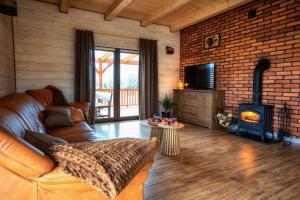 ein Wohnzimmer mit einem Sofa und einem Holzofen in der Unterkunft Sielski Spokój Gietrzwałd in Gietrzwałd