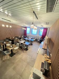 ein Restaurant mit Tischen und Stühlen in einem Raum in der Unterkunft FlyInn-Pension Airport-Messe in Leinfelden-Echterdingen + 30 Fotos