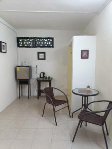 een kamer met 2 tafels en 2 stoelen en een keuken bij Casa Polito in Izamal