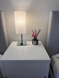 a white table with a lamp and flowers on it at Exquisite City Centre Apartment - 2 Bed 2 Bath - Free Parking - Netflix Amazon Disney Enabled Smart TV in Birmingham +12 photos