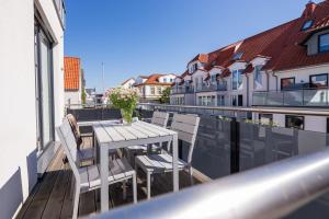 ein Balkon mit Tisch und Stühlen auf einem Gebäude in der Unterkunft Robbenloft in Norderney