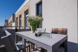 ein Tisch mit einer Vase mit Blumen auf einem Balkon in der Unterkunft Robbenloft in Norderney