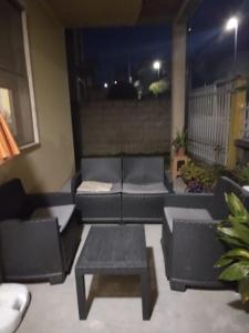 un patio con divani e un tavolo sul balcone. di Casa Cera Arras a Dolianova