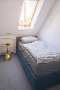 een bed in een kamer met een raam en een tafel bij Hotel & Restaurant Hasa in Gernrode - Harz +5 foto's