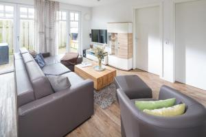 een woonkamer met twee banken en een tv bij Utspann in Norderney