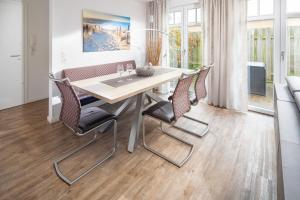 een eetkamer met een tafel en stoelen bij Utspann in Norderney