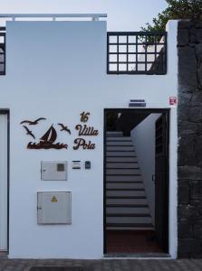 a white building with a staircase with birds on it at Villa Pola Marinas Playa B in Playa Blanca