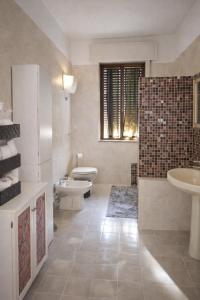 bagno con 2 servizi igienici, lavandino e doccia di Casa Cera Arras a Dolianova