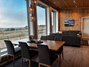 a living room with a table and a couch at Unik og moderne hytte med utsikt mot havet 38 Otterlei Resort in Haram