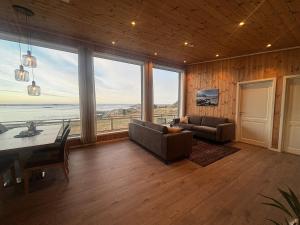 a living room with a view of the ocean at Unik og moderne hytte med utsikt mot havet 38 Otterlei Resort in Haram